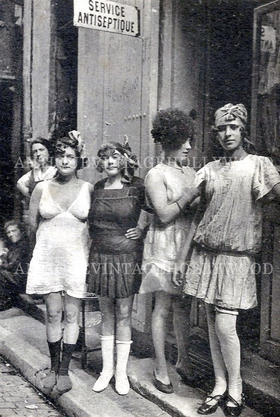 This historical photograph shows women at the entrance to a brothel in the red-light district of Marseille (France) in the early 20th century. А00078
