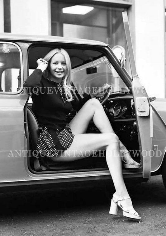 British model and actress Jenny Clare next to a classic Mini in London in 1972. А00102